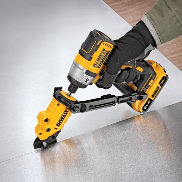 Outil DEWALT équipé coupe une tôle, utilisé par une main gantée.